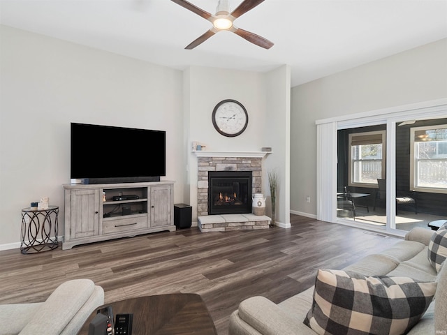 living room featuring hardwood / wood-style flooring, ceiling fan, and a fireplace