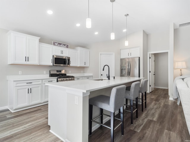 kitchen with white cabinetry, appliances with stainless steel finishes, and a center island with sink