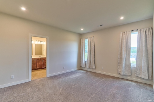 spare room with light colored carpet and a wealth of natural light