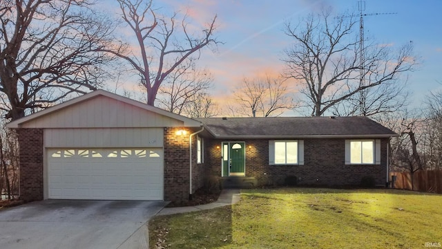 single story home with a garage and a lawn