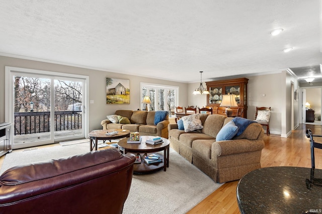 living room featuring ornamental molding, a textured ceiling, light hardwood / wood-style flooring, and a wealth of natural light