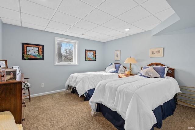 bedroom with a paneled ceiling and light colored carpet