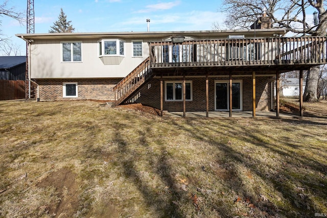 rear view of house featuring a wooden deck and a lawn