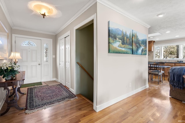 foyer featuring ornamental molding and light hardwood / wood-style flooring