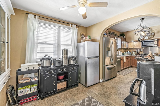 kitchen featuring decorative light fixtures, ceiling fan, and appliances with stainless steel finishes