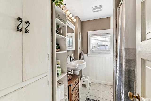 bathroom featuring sink, curtained shower, and tile patterned floors