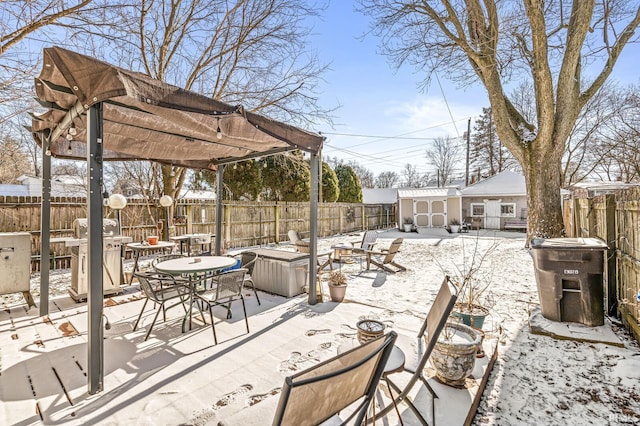 snow covered patio featuring a shed