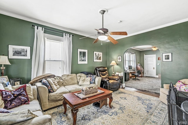 living room featuring hardwood / wood-style flooring, ornamental molding, and ceiling fan