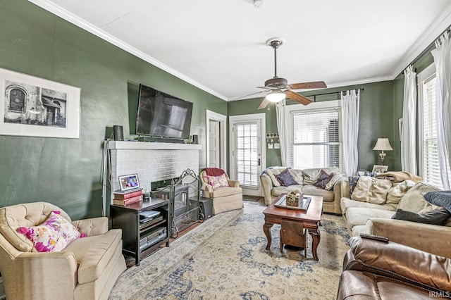 living room with hardwood / wood-style floors, crown molding, a fireplace, and ceiling fan