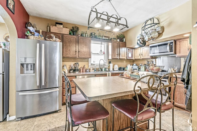 kitchen with appliances with stainless steel finishes, a center island, and sink