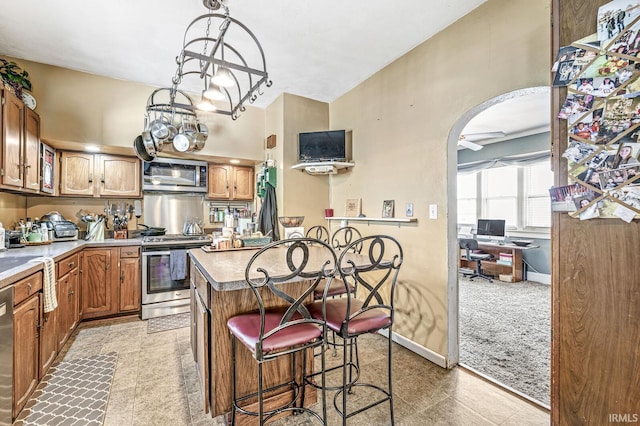 kitchen featuring an inviting chandelier, a breakfast bar area, a center island, and appliances with stainless steel finishes