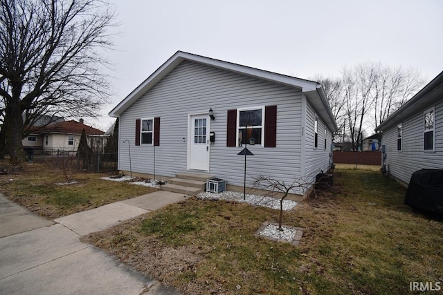 view of front facade featuring cooling unit and a front lawn