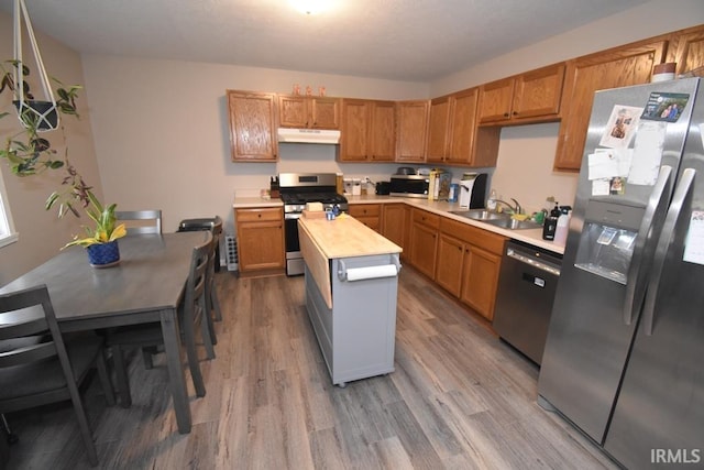 kitchen with hardwood / wood-style flooring, stainless steel appliances, butcher block counters, and sink