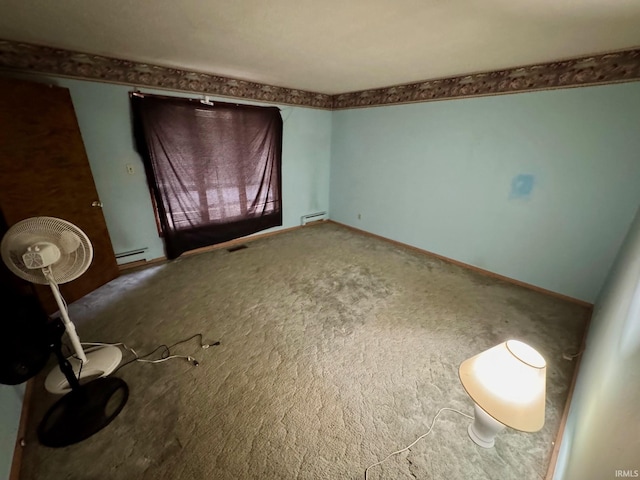 empty room with a baseboard heating unit and carpet flooring