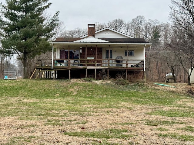 back of property with a lawn and covered porch