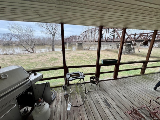 wooden terrace featuring area for grilling, a water view, and a yard