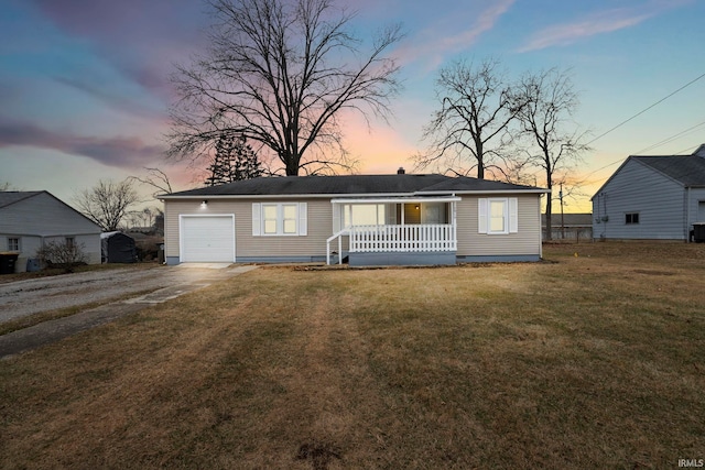 ranch-style house with a porch, a garage, and a yard