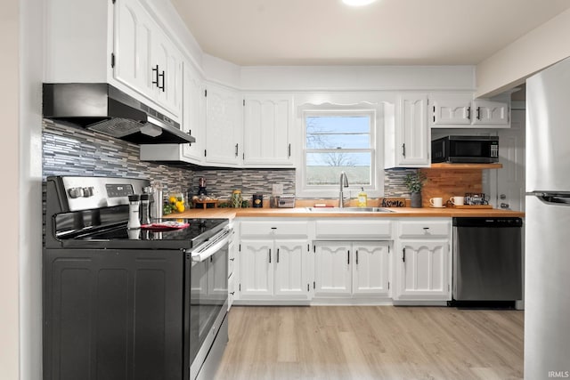 kitchen with tasteful backsplash, white cabinetry, sink, stainless steel appliances, and light hardwood / wood-style flooring