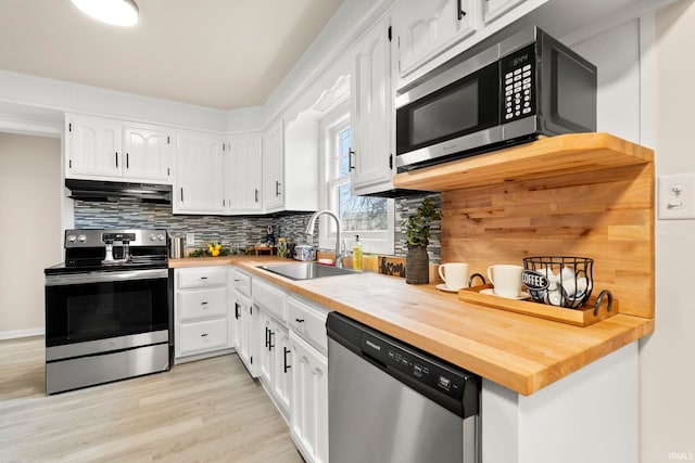 kitchen featuring stainless steel appliances, white cabinetry, and sink