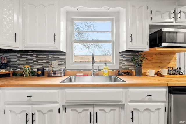 kitchen featuring tasteful backsplash, sink, stainless steel appliances, and white cabinets