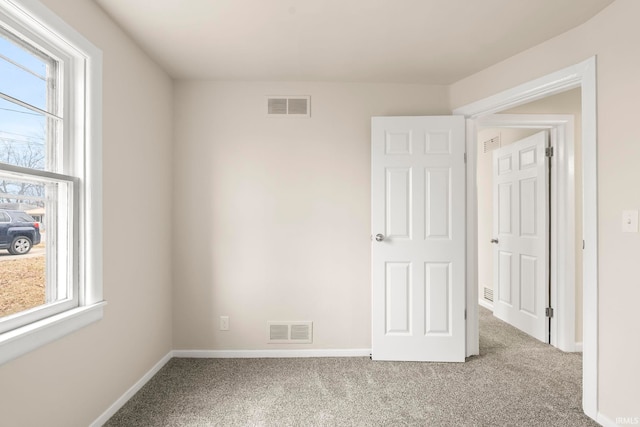 carpeted spare room featuring a healthy amount of sunlight