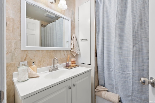 bathroom featuring tile walls, vanity, and decorative backsplash