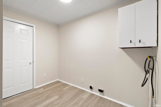 washroom featuring cabinets, hookup for a washing machine, and light hardwood / wood-style floors