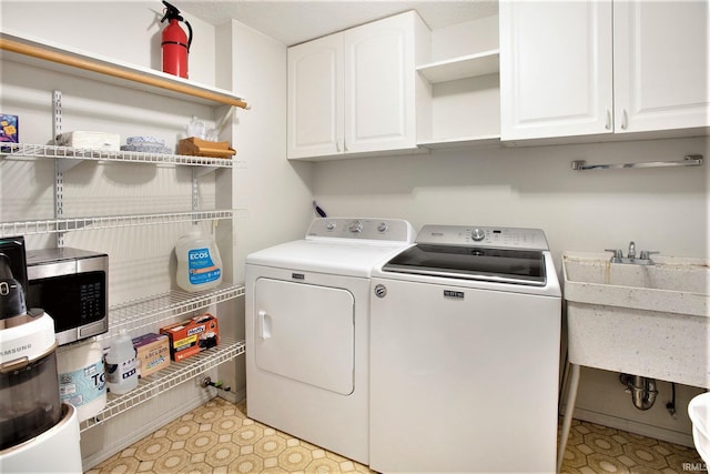 laundry area with cabinets, sink, and washer and clothes dryer