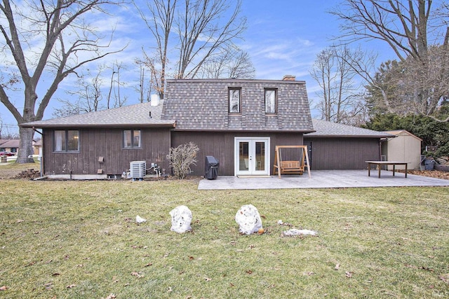 rear view of house with central AC, a patio, french doors, and a lawn