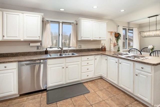 kitchen featuring sink, white cabinetry, decorative light fixtures, stainless steel dishwasher, and kitchen peninsula