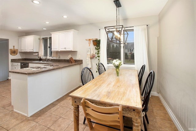 tiled dining room featuring sink and a chandelier