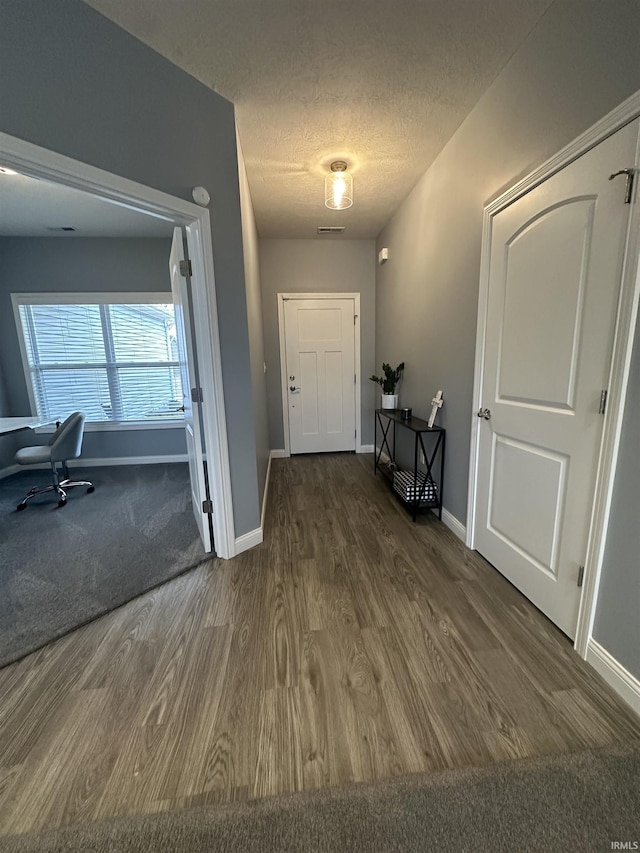 interior space featuring dark hardwood / wood-style flooring and a textured ceiling