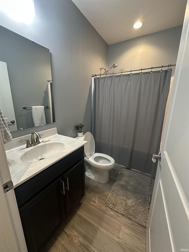 bathroom featuring vanity, toilet, a shower with shower curtain, and wood-type flooring