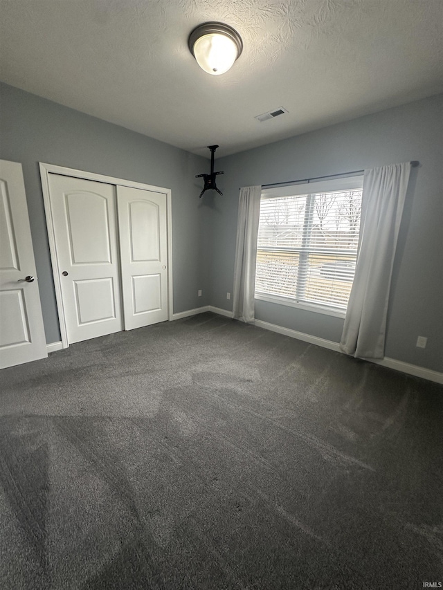 unfurnished bedroom with a closet, a textured ceiling, and carpet