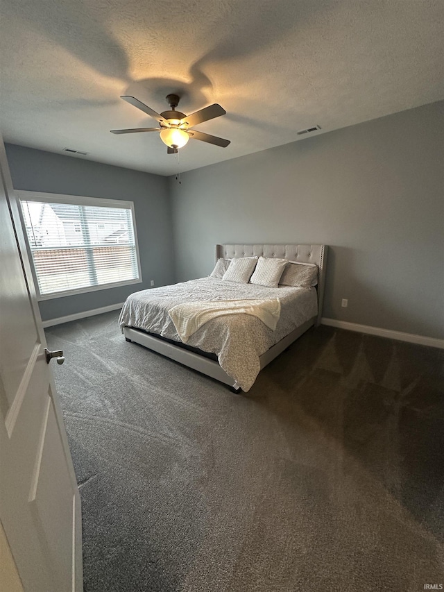 bedroom with ceiling fan, carpet, and a textured ceiling