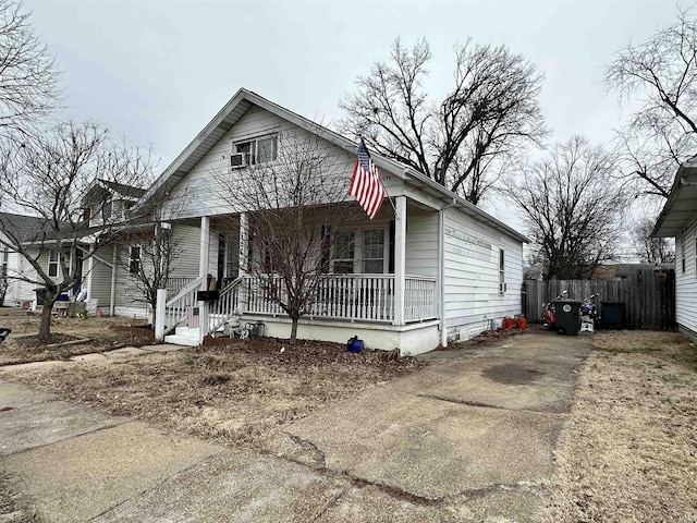 view of front facade with a porch, fence, and driveway