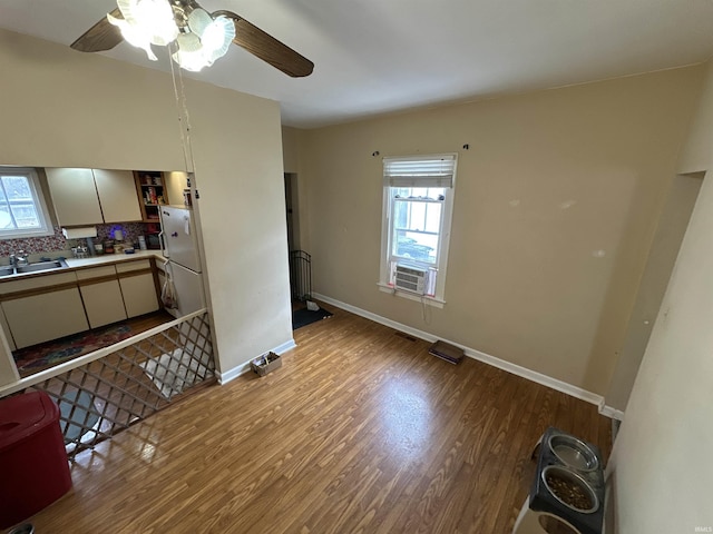 interior space with baseboards, light countertops, decorative backsplash, light wood-style floors, and a sink