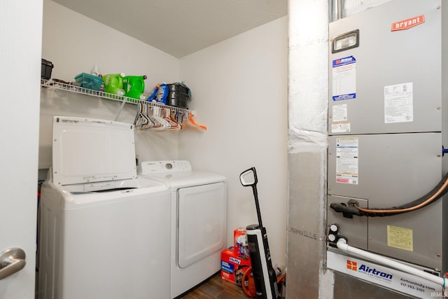 clothes washing area featuring heating unit, dark hardwood / wood-style flooring, and washing machine and dryer