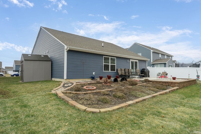 rear view of house with a storage unit, a yard, and a patio area