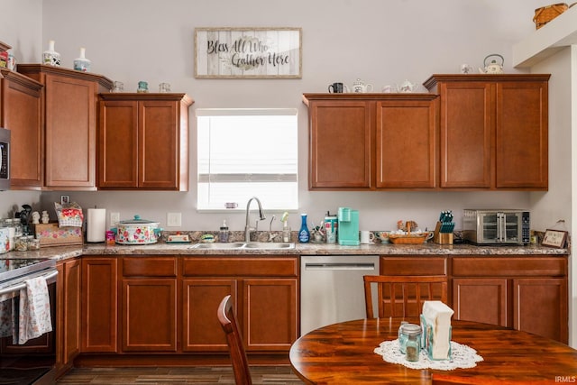 kitchen featuring stone countertops, appliances with stainless steel finishes, and sink