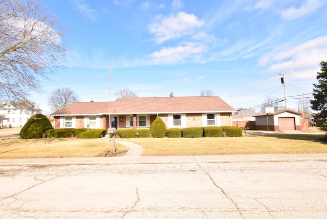 view of front of house featuring an outbuilding, a garage, and a front yard