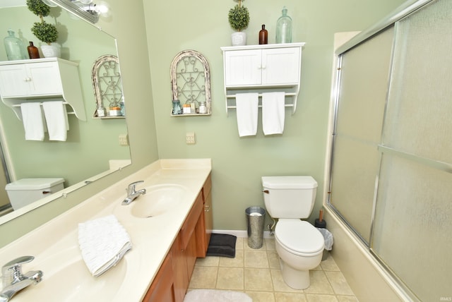 full bathroom featuring vanity, tile patterned flooring, bath / shower combo with glass door, and toilet