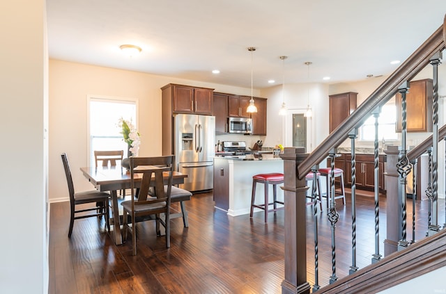 dining room featuring dark wood-type flooring and a wealth of natural light