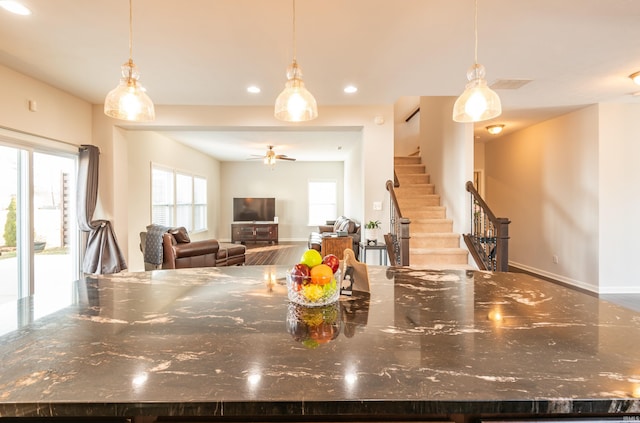 kitchen featuring dark stone countertops, hanging light fixtures, and a center island