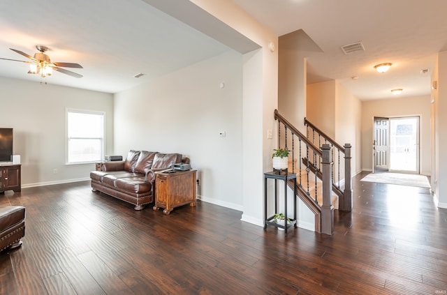 living room with dark wood-type flooring and ceiling fan