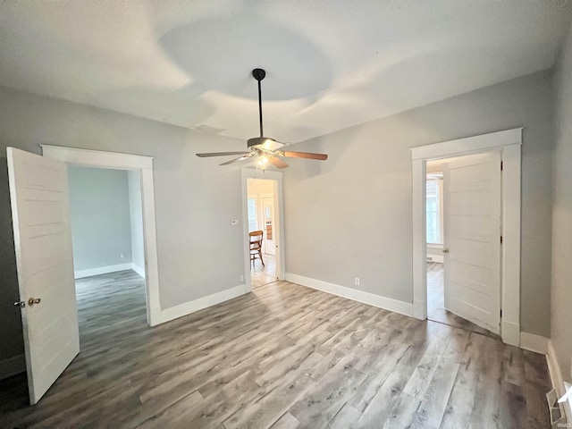 unfurnished living room featuring ceiling fan and light wood-type flooring