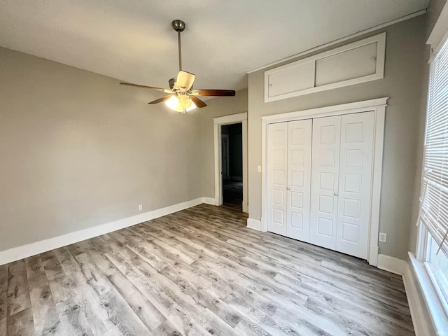 unfurnished bedroom with ceiling fan, light wood-type flooring, and a closet