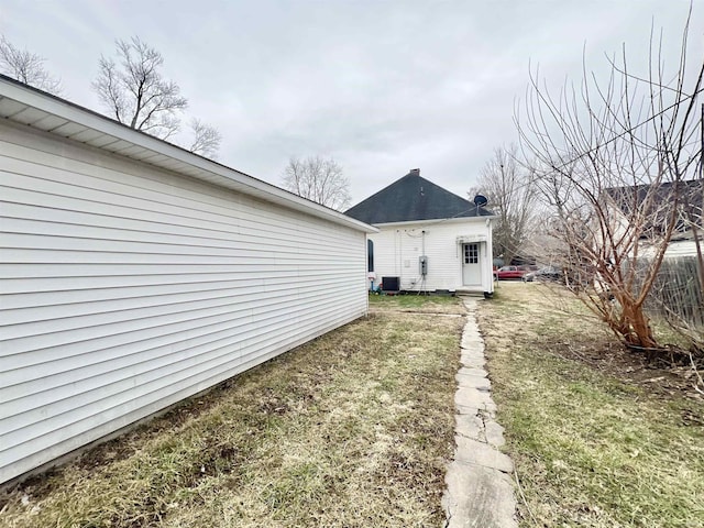 exterior space with central AC and a lawn