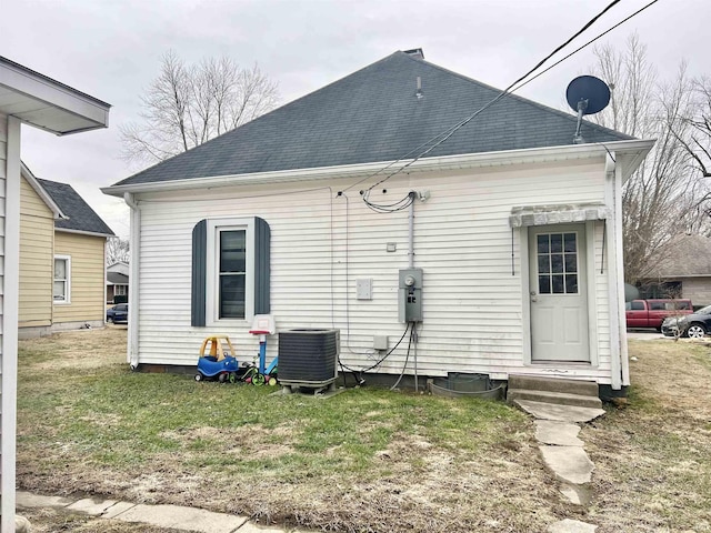 back of property featuring a yard and cooling unit