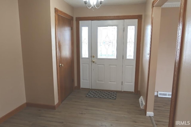 foyer featuring a chandelier and light hardwood / wood-style floors